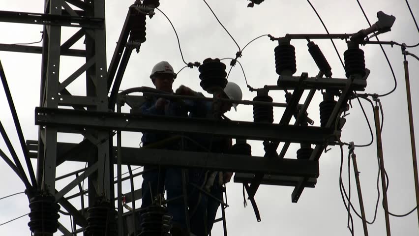 Electricians in a bucket fixing high voltage electrical lines