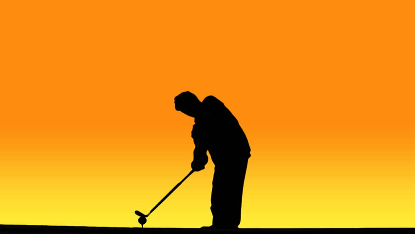 Silhouette of golfer swinging club, hitting ball, against sunset background.