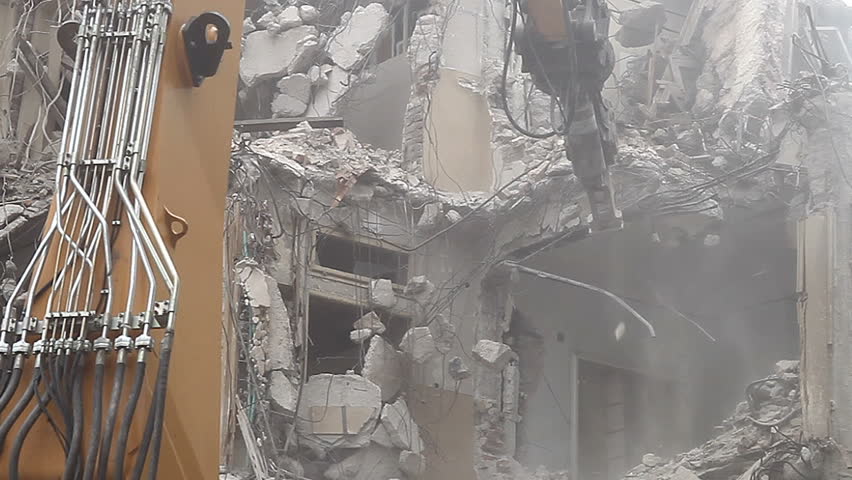 Demolition. Breaking a wall. Dust, debris and water. Detail. Falling debris. 