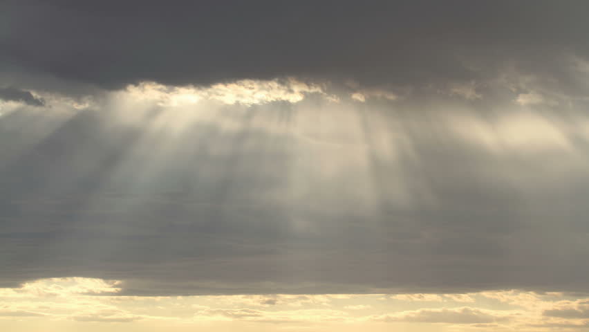 Time lapse of dramatic rain clouds and rays of sunlight
