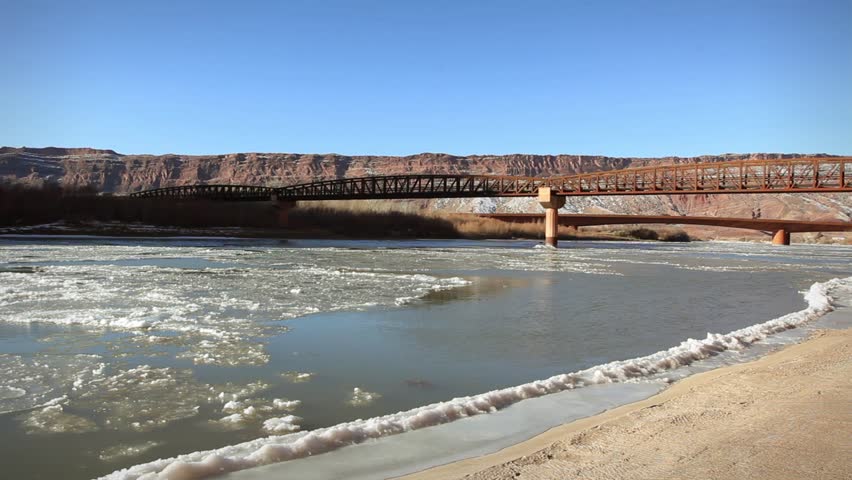 Frozen winter Colorado river and bridge Moab Utah