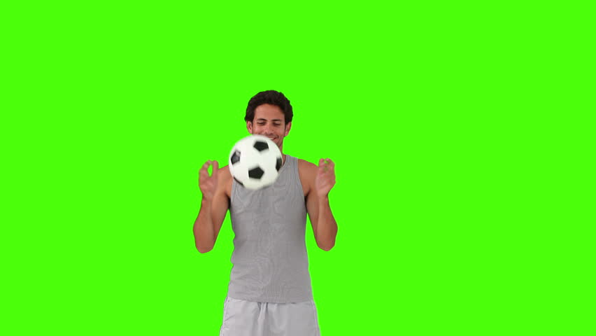 Chromakey footage of a dark-haired man in sportswear playing with a soccer ball