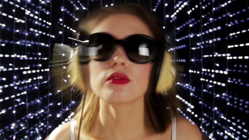 close-up of the face of a beautiful woman wearing sunglasses and headphones, listening to music, with abstract photographic effect