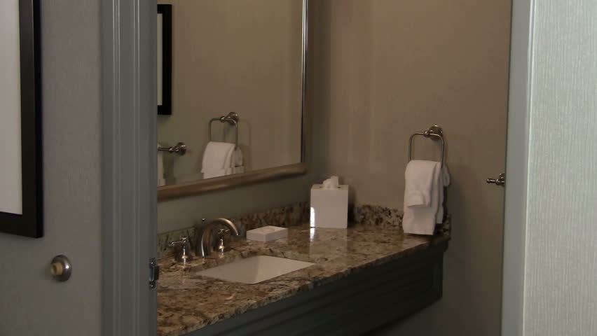 Maid exists bathroom with towels presents them to camera - HD