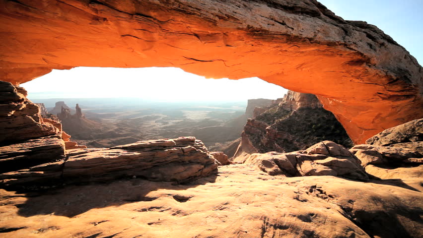 Glow of the rising sun seen through the famous Mesa Arch, in Utah USA