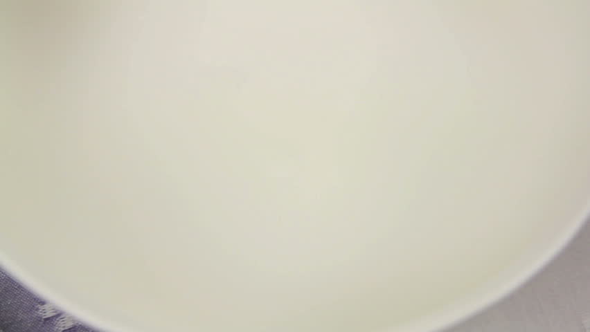 Beating and whisking eggs and milk into a mixture for scrambled eggs.