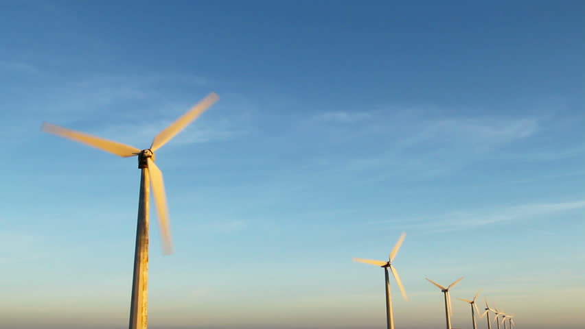 Row of wind turbines with rotating blades.