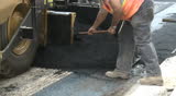 Asphalt finisher laying down a fresh layer of asphalt