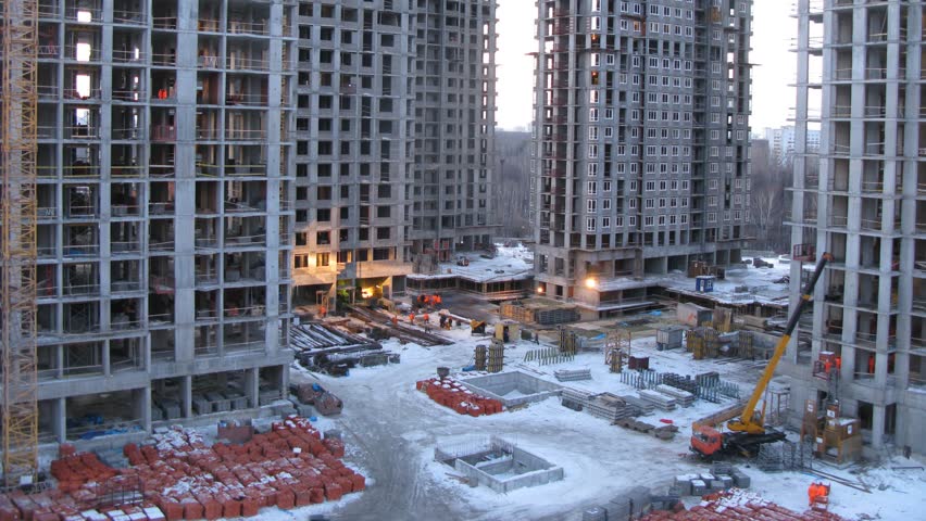 Builders and machinery work in the evening, zoom view, time lapse
