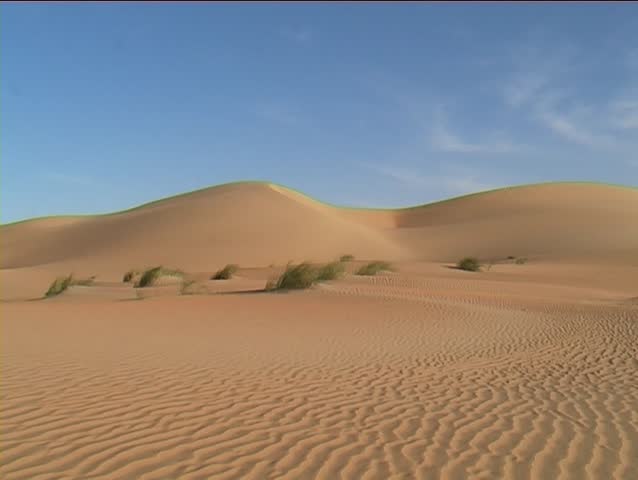 Man climbing a sand dune in the Mauritanian Sahara.