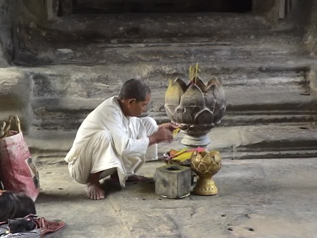Buddhist nun burning inscence in Angkor Wat temple, Cambodia.