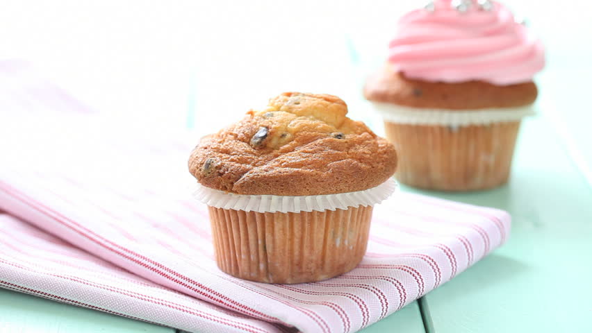 placing chocolate icing on cupcake