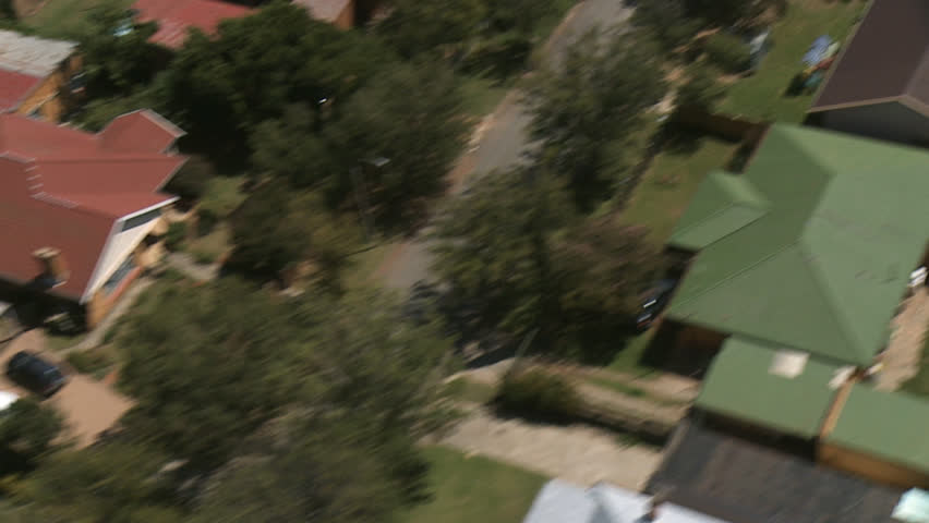 Helicopter shot over suburb with swimming pools.