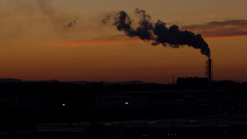 Sunrise timelapse of silhouette of smoking factory