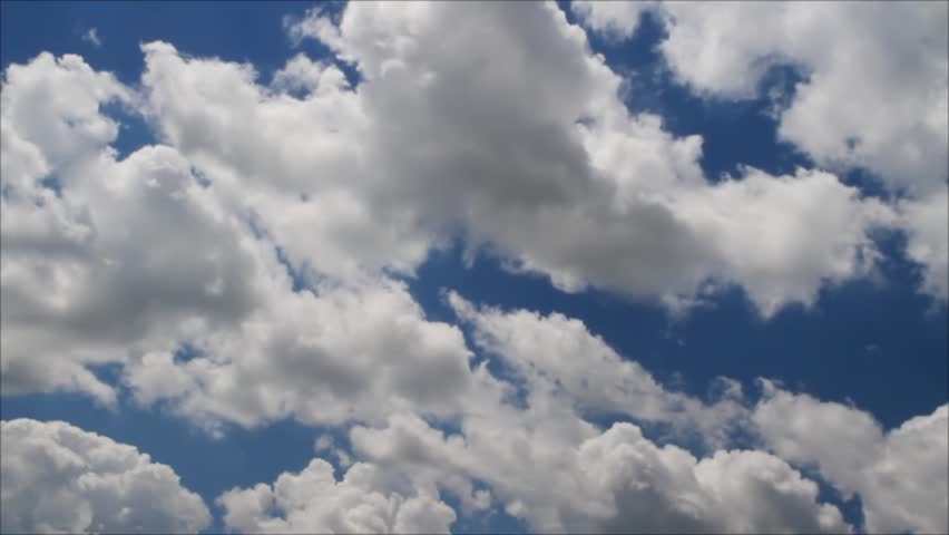 White puffy clouds move across a brilliant blue sky in time lapse fashion. Looping skyscape background.