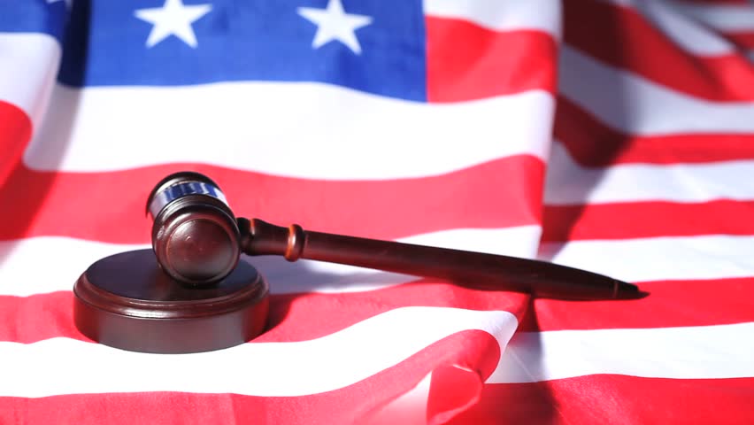 Closeup of a gavel raised on an American flag