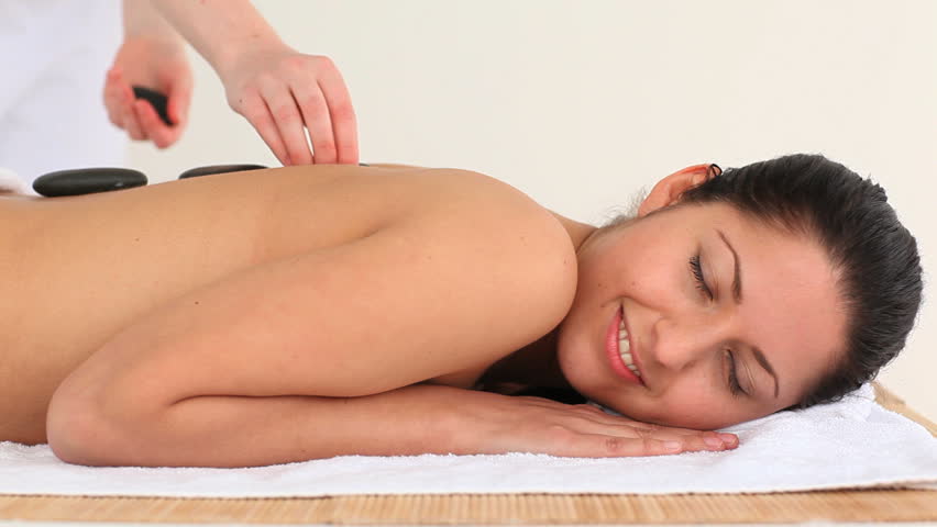 Brunette having a treatment with hot stones in a Spa center