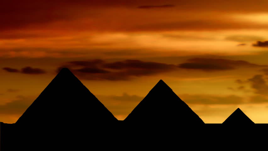 Egyptian pyramids at orange dusk.