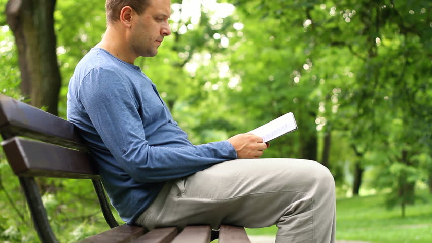 Young man in the park with back pain, camera stabilizer shot