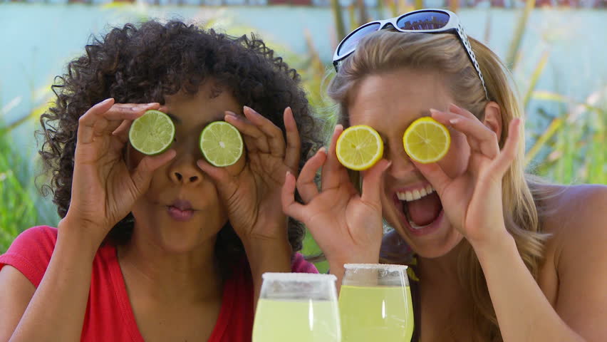 Two women friends goofing around by the pool