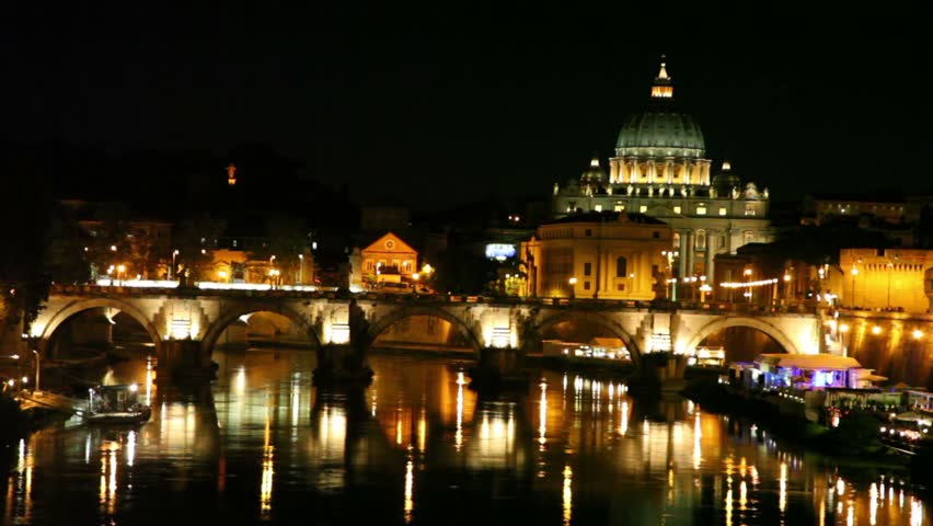 Sant Angelo Bridge side view and Sant Peters Cathedral at night, river flow and cafe on quay are also shown