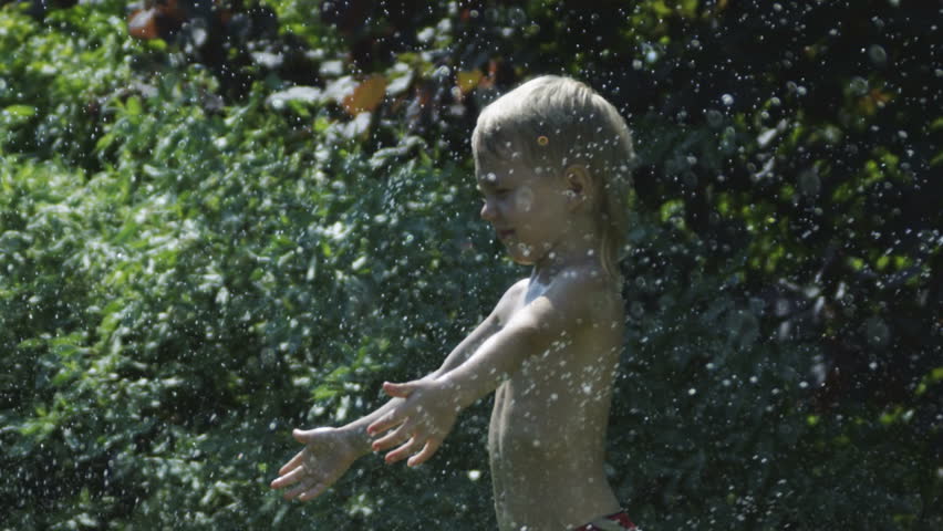 Boy standing in rain.