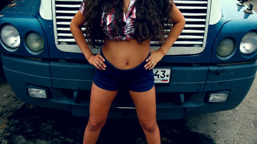 Beautiful Girl stands at front of truck on sunset