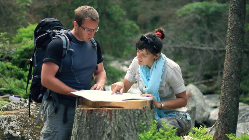 A couple with map and compass in the forest 