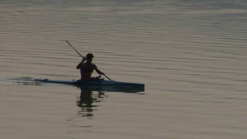 Athletic man kayaking in a lake