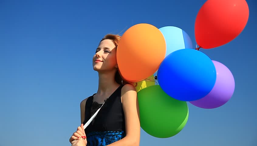 Redhead girl with color balloons.