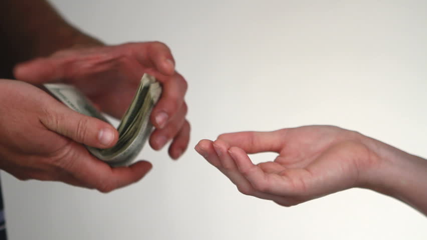 Close up of paying cash from man's hands counting out one hundred dollar bills into a woman's hand.