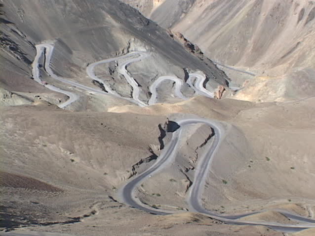 A windy road curves through high mountains.