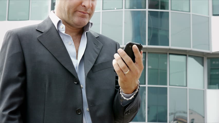 Happy businessman with mobile telephone or smartphone, visiting web site and browsing the internet