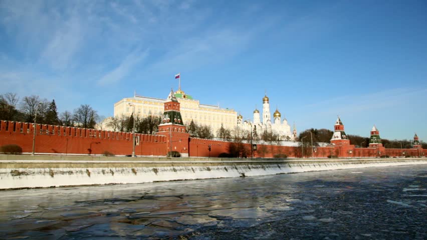 Quay and red brick walls of Moscow Kremlin and Ivan Great Bell Tower at winter
