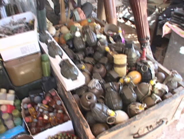 IRAQ - CIRCA 2003: A weapons dealer watches over a pile of grenades circa 2003 in Northern Iraq.