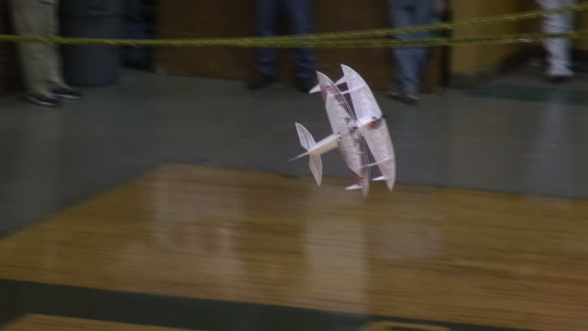 Radio-controlled foam model airplane performing aerobatic tricks at the competition venue