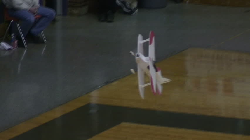 Radio-controlled foam model airplane performing aerobatic tricks at the competition venue
