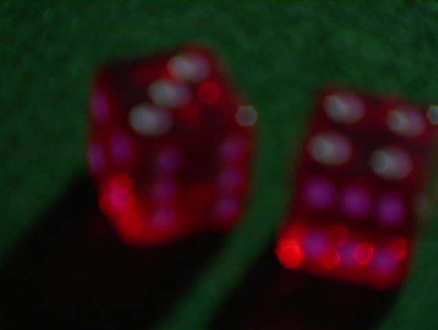 red dice sit on a green table.