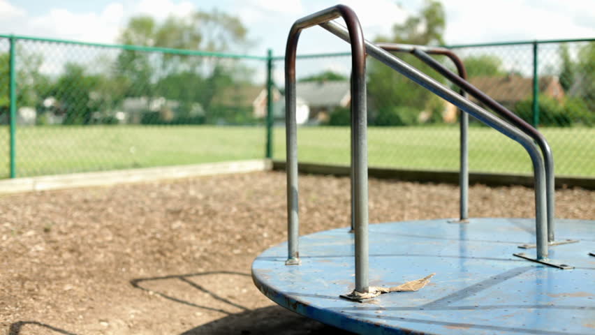 Empty merry go round spinning in kids playground