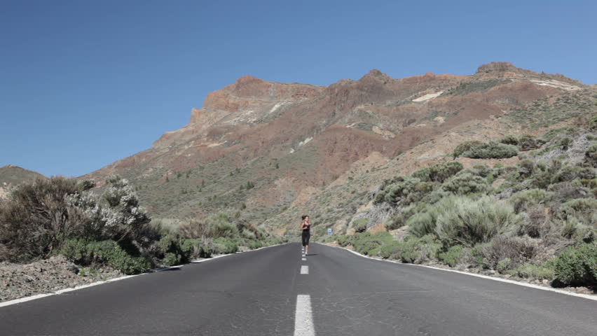 Runner. Woman running in dramatic landscape. female fitness model jogging on Tenerife, Teide, Canary Islands, Spain.