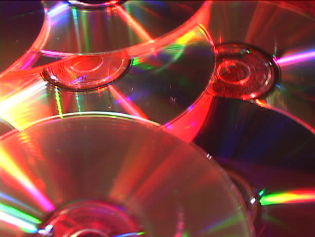 Colored lights reflect off revolving compact discs.