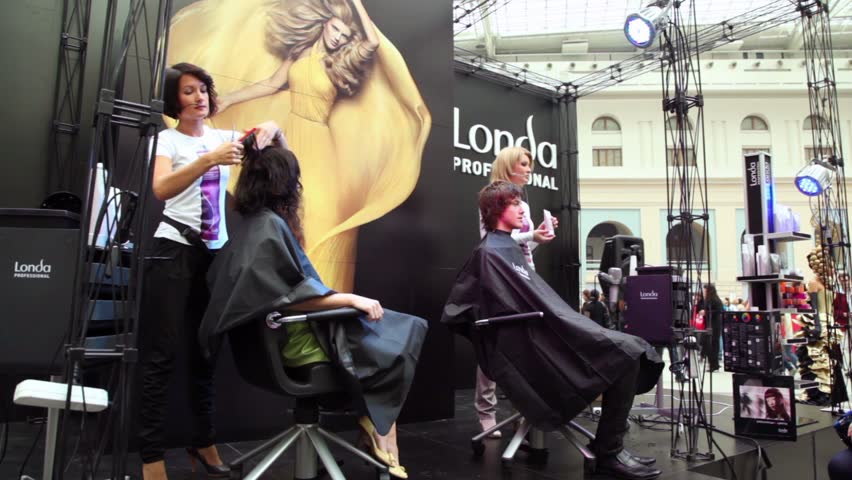 MOSCOW - OCT 2: Two hairdressers make hairstyle at master class from Londa at XVII International Festival World of Beauty 2010 in exhibition complex Gostiny Dvor, on Oct 2, 2010 in Moscow, Russia. 
