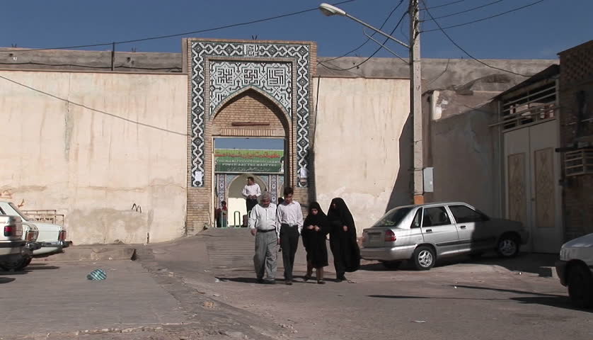 IRAN - CIRCA 2010: Two women wearing chadors and two men pass on a street circa 2010 in Iran.