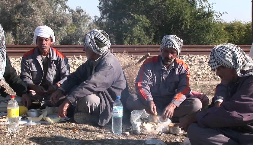 IRAN - CIRCA 2010: Men wearing the traditional muslim headdress, or keffiyeh, sit by a fire outside circa 2010 in Iran. 