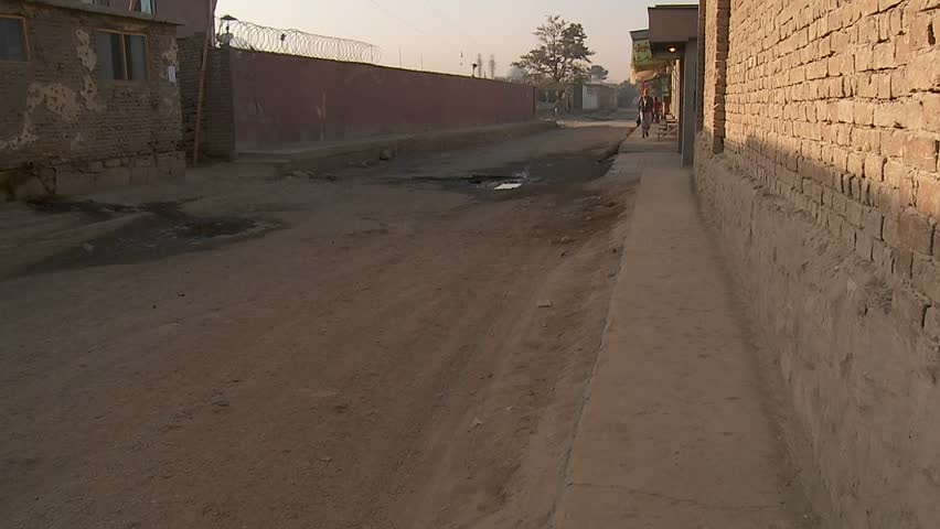 KABUL, AFGHANISTAN - CIRCA 2009: Pedestrian walks on a dirt road alley circa 2009 in Kabul, Afghanistan. Afghanistan is an impoverished and least developed country, one of the world's poorest. 