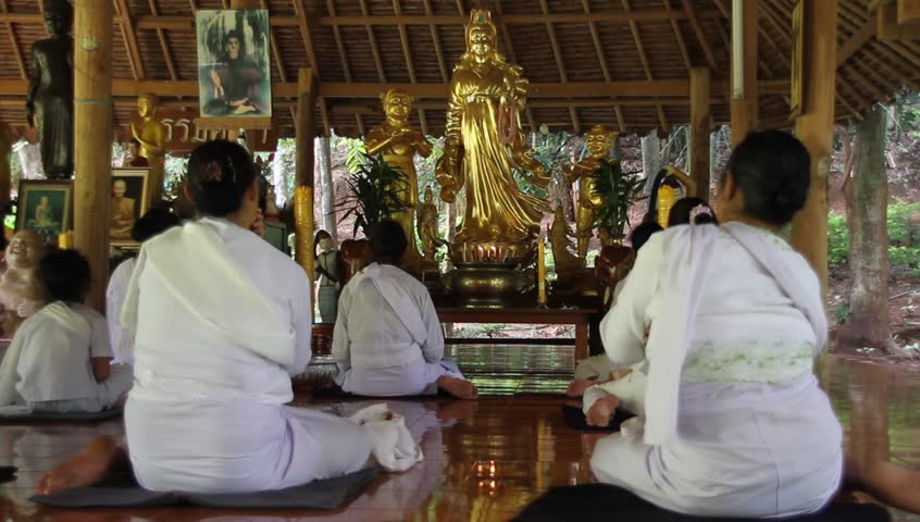 Women in meditation inside wooden temple