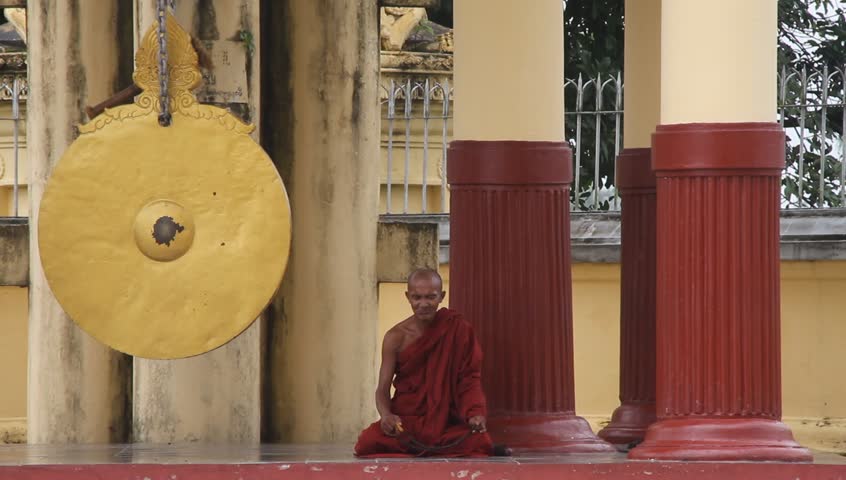 YANGON, MYANMAR - AUGUST 18: Buddhist monk prays near shrine in buddhist temple Ne Vin on August 18, 2011 in Yangon, Myanmar. Buddhist monks, who are venerated throughout Burmese society