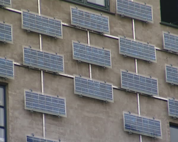 Building wall with lot of solar collectors. Renewable ecological solar energy. 