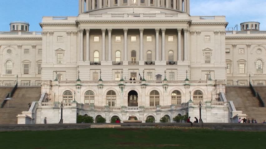 The camera pans up the U.S. Capitol building in Washington, DC from ground level to its landmark rotunda and dome.