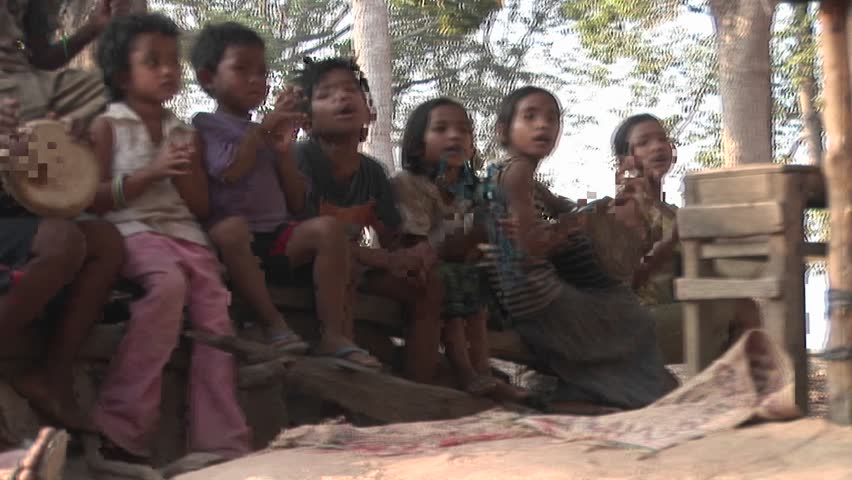 CAMBODIA - CIRCA 2009: A man and group of young children sing and play musical instruments at Khmer monument in Angkor Wat circa 2009 in Cambodia.